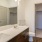 spacious bathroom on wood-style flooring with a large vanity mirror